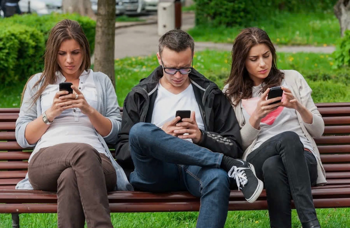 People looking down at their phones instead of at each other